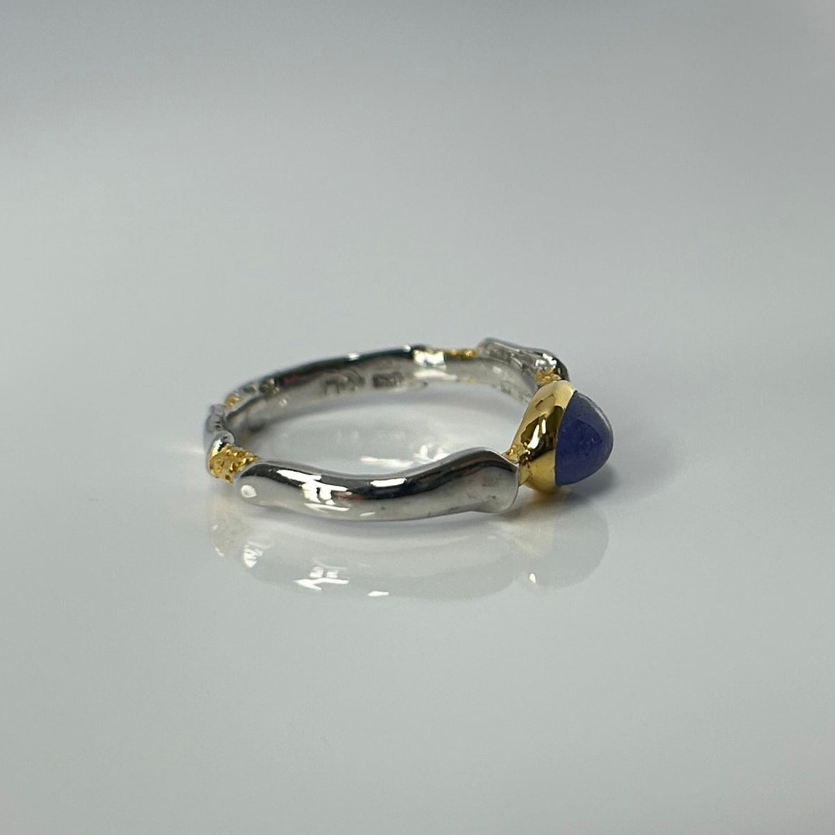 Silver ring with a blue tanzanite gemstone on a gray background