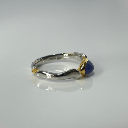 Silver ring with a blue tanzanite gemstone on a gray background