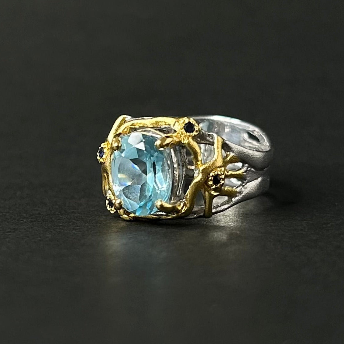 Ring with a blue gemstone on a black background