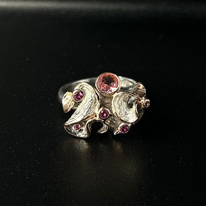 Silver ring with pink tourmaline gemstones on a black background