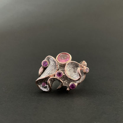 Silver ring with gemstones on a dark background