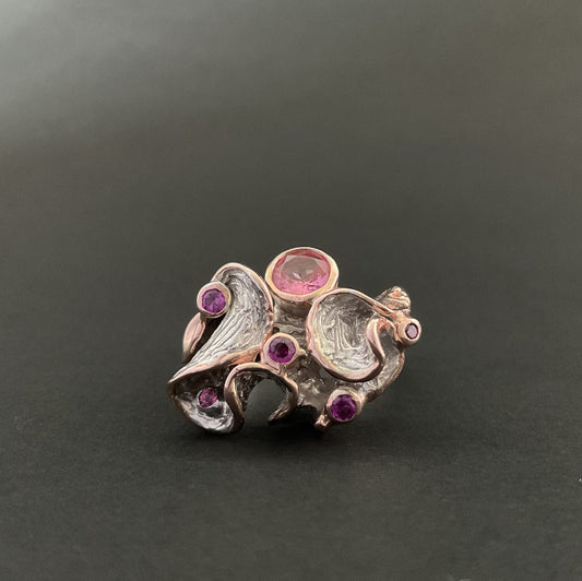 Silver ring with gemstones on a dark background