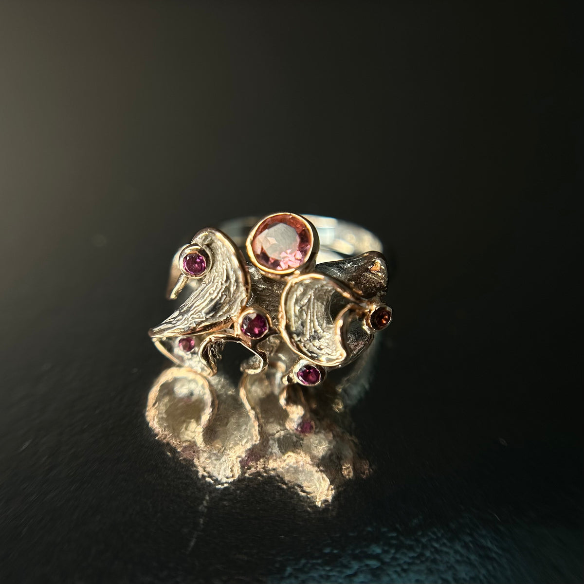 Silver ring with gemstones on a black background