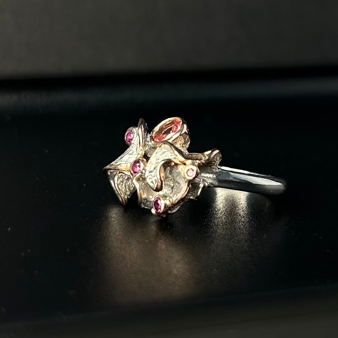 Silver ring with gemstones on a black background