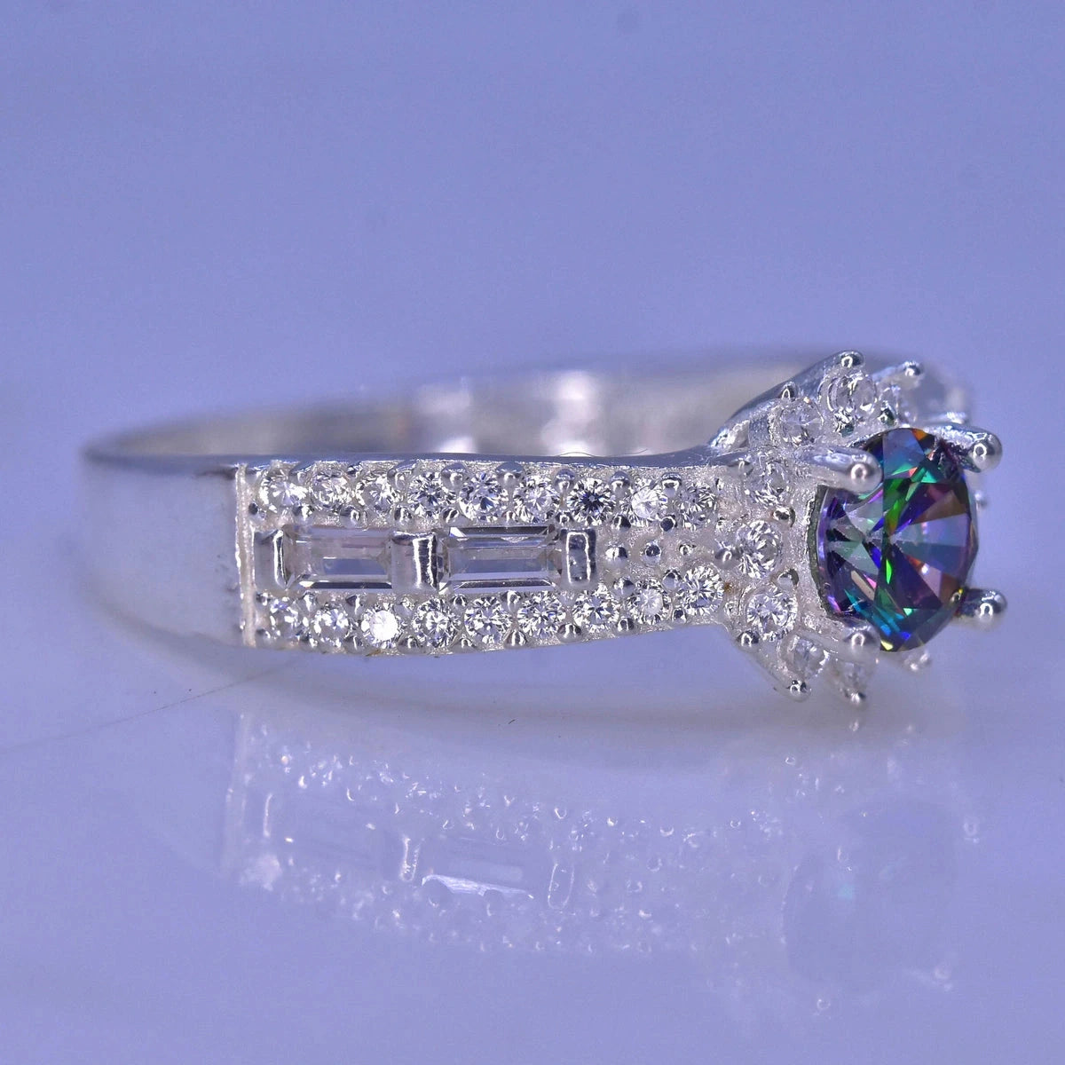 Silver ring with a colorful mystic quartz on a light purple background